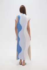 Vestido largo de viscosa con estampado abstracto en tonos beige, amarillo y negro. Tiene cuello en V, mangas cortas, corte holgado y tajo lateral.