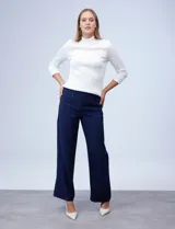 Pantalón negro de pierna ancha, marca Zac & Rachel. Pretina ancha con aplique de botones y bolsillos simulados con tachas.