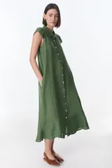 Vestido camisero celeste de lino, corte midi, con cuello camisero, mangas cortas con volados y abotonadura frontal.