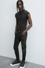 Pantalón de jean celeste de corte skinny con roturas en las rodillas y terminación desflecada.