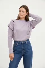 Sweater de poliamida color lila, de corte ajustado, con cuello redondo a la base y volados decorativos en el pecho y los hombros.
