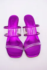 Sandalias plateadas con taco de forma geométrica y tiras transparentes.