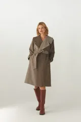 Tapado largo color beige con diseño de espiga, cuello solapa, cierre cruzado con cinturón y bolsillos laterales. Confeccionado en lana fina sin teñir.