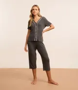 Conjunto de pijama americano gris oscuro, confeccionado en viscosa. Incluye una blusa de manga corta con cuello en V, abotonada al frente y detalle contrastante en blanco, y un pantalón capri con cintura elástica.