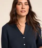 Camisa amarilla de viscolino con escote en pico, manga larga y botonadura frontal.