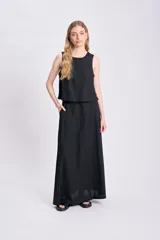 Falda larga negra de lino, corte recto y bolsillos laterales.