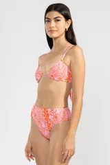 Conjunto de bikini de dos piezas con estampado de flores y caritas sonrientes en tonos rosados y naranjas. El corpiño es triangular con breteles finos y la bombacha es de tiro alto con cobertura mínima.
