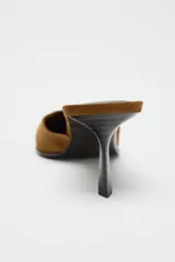 Zapato tipo mule destalonado color marrón, de ante, con escote redondo, punta fina y tacón medio fino.