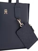 Cartera tote compacta Tommy Hilfiger color azul marino, con acabado liso y logo TH en relieve. Incluye monedero extraíble con cremallera, doble asa superior y correa tejida ajustable y extraíble.