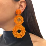 Aros colgantes largos con forma de círculos tramados con cuentas de cristal color turquesa.