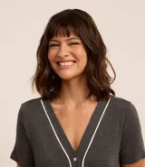 Conjunto de pijama gris oscuro confeccionado en viscosa, compuesto por una camisa de manga corta con cuello en V, abotonada adelante y detalle contrastante blanco; y un pantalón capri con cintura elástica.