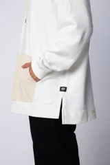Buzo canguro blanco con capucha forrada en beige y bolsillo tipo parche color beige. Estampa con logo en el pecho.