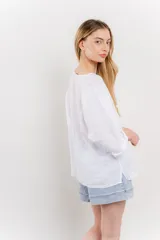 Blusa color beige confeccionada en lino, de corte holgado, mangas 3/4 y cuello redondo.