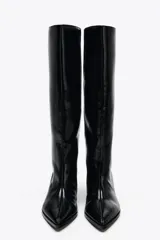 Bota de caña media color negro, de cuero sintético, con punta fina y taco kitten.