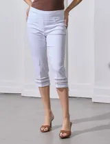 Pantalón capri blanco de gabardina elastizada con bolsillos simulados, pretina ancha, corte recto y detalle de puntilla en el ruedo.