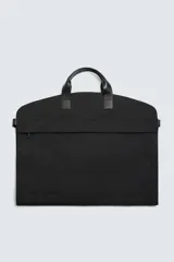 Portatrajes negro confeccionado en tejido técnico. Cuenta con un compartimento principal con cierre mediante cremallera, dos bolsillos auxiliares con cierre mediante cremallera y asas de mano fabricadas en piel.