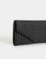 Billetera negra con textura matelaseada en forma de espiga. Tiene solapa con broche a presión.