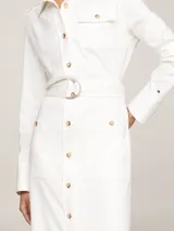 Vestido camisero midi color blanco, de corte recto, con cuello camisero, manga larga, cinturón con hebilla y múltiples bolsillos.