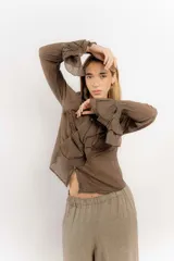 Camisa celeste de algodón con cuello alto y volados frontales. Mangas largas con puños fruncidos.