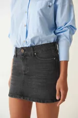 Minifalda de denim azul con tiro a la cadera, terminación recta y bolsillos funcionales.