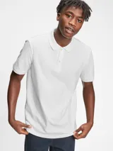 Remera polo de piqué blanco, suave y elástico, con manga corta y cuello de canalé.