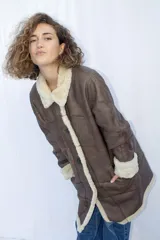 Abrigo gamulán marrón con cuello y solapa de piel sintética color crema, cierre con botones y bolsillos laterales.