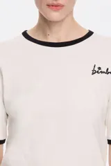 Camiseta blanca de algodón con cuello redondo y mangas cortas con ribete negro. Logotipo de la marca bordado en el pecho.