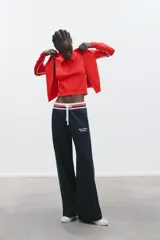Chaqueta de punto roja con escote pico y manga larga. Tiene vivos laterales combinados a contraste y cierre frontal con botones forrados a tono.