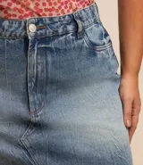 Pollera corta de jean de lavado diferenciado, con trabillas en la cintura, cierre delantero y bajo con corte a hilo.