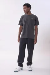 Remera gris oscuro con efecto lavado, cuello redondo y logo pequeño bordado en el pecho.
