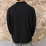 Chomba polo negra de micropanal, corte boxy y mangas largas.