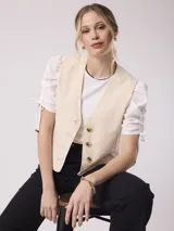 Chaleco color crema de lino y algodón con botones.