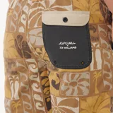 Short de baño Rip Curl modelo Aots Ty Williams, color negro con cintura beige y estampado abstracto en tonos ocre en la parte inferior.