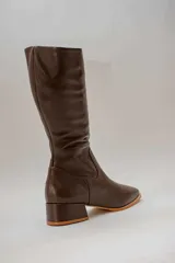 Bota de caña alta de cuero color rojo, con cierre lateral y taco cuadrado de 4 cm.