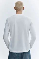 Remera blanca de punto de algodón liviano, de corte regular y manga larga.