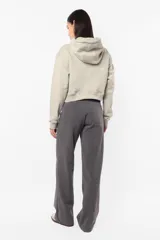 Buzo crop de frisa gamuzada color beige. Diseño con bolsillo canguro delantero, capucha con forrería interna, ojalillos metálicos de marca, cordón ajustable con punteras metálicas, puños y cintura en rib.