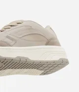 Championes urbanos color beige, confeccionados en material sintético, con recortes laterales, cordones y suela alta con detalles contrastantes.