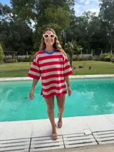 Remerón oversize tejido en hilo a rayas horizontales rojas y beige, con cuello redondo azul.