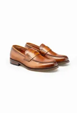 Mocasín de cuero color marrón claro, con antifaz y suela de cuero.