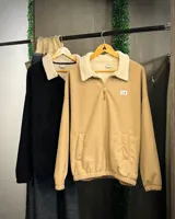 Buzo beige de pana con cuello alto forrado en corderito blanco, cierre parcial con cremallera, puños y cintura elastizados.