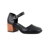 Sandalia de cuero sintético negro con pulsera al tobillo y hebilla plateada. Tiene taco de madera de 6 cm y punta cuadrada.