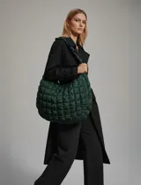 Bolso de hombro acolchado color verde oscuro, con diseño capitoné de rombos y cierre superior con cremallera.