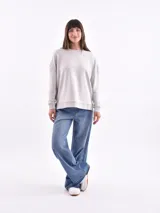 Sweatshirt color gris claro, de corte holgado y mangas largas.