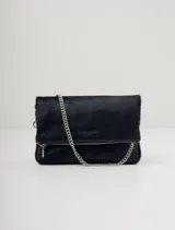 Bandolera negra de cuero con textura de pelo, solapa frontal y cierre con cremallera. Incluye correa corta de cadena plateada y correa larga desmontable de cuero con eslabones metálicos plateados.