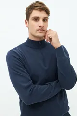 Buzo azul marino de tejido de punto con cuello alto y medio cierre con cremallera.
