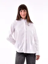 Camisa blanca con detalle de frunces en el cuello y puños, de corte clásico y mangas largas.