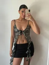 Top de fiesta negro con lentejuelas plateadas, escote en V y tirantes finos.