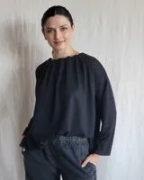 Remera negra de mangas largas con cuello fruncido.