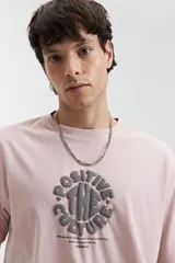 Remera de manga corta color rosa pálido con estampado circular en el frente.
