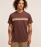 Remera marrón de algodón con cuello redondo y mangas cortas. Presenta dos rayas horizontales en el pecho, una color crema y otra color beige.